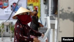 베트남 호치민시에 설치된 무료쌀배급기에 주민이 쌀을 받고 있다.