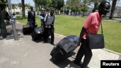 South Sudanese men carry luggage as they walk towards Tel Aviv's central bus station to board a bus to Ben Gurion airport, Israel, June 17, 2012. 