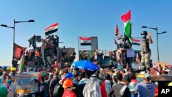 Anti-government protesters control some barriers set by Iraqi security forces to close the bridge leading to the Green Zone during ongoing protests in Baghdad, Iraq, Nov. 1, 2019.