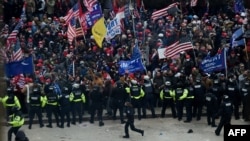 Para polisi berusaha menghalangi para pendukung Presiden Donald Trump yang berkumpul di luar Gedung Kongres, di Washington D.C., 6 Januari 2021.
