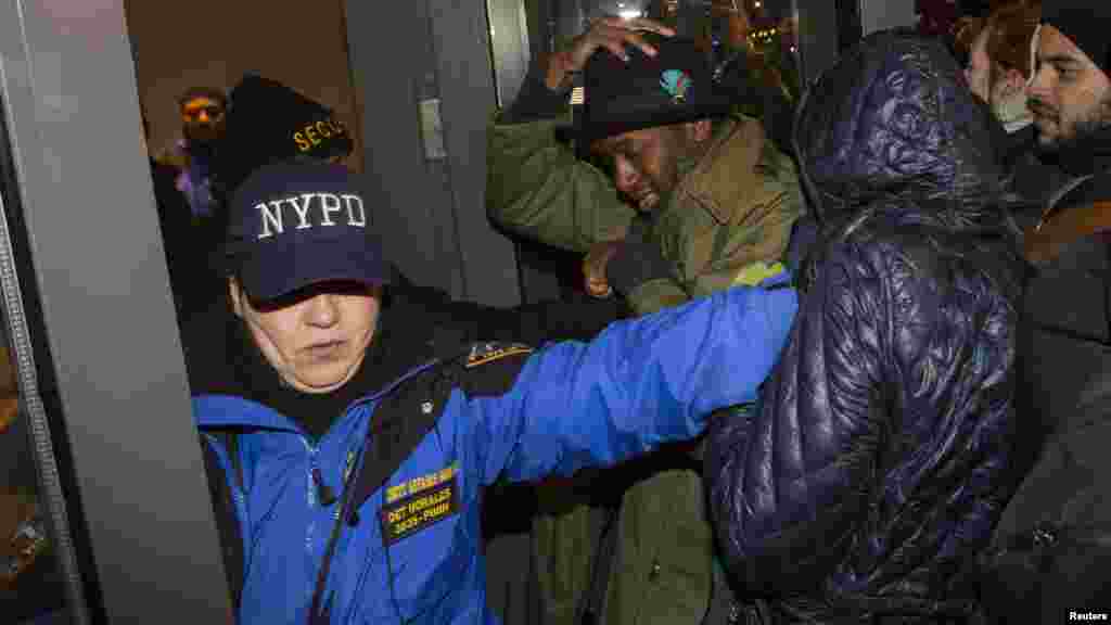A relative, right, of one of the victims of explosion, wipes the face of a Turkish police officer, serving as a honor guard, during the funeral procession for two of the victims at Fatih mosque in Istanbul.