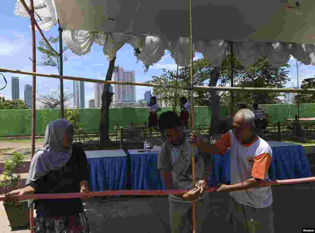 Sukarelawan mempersiapkan TPS untuk pemilu legislatif di Jakarta, 8 April 2014.