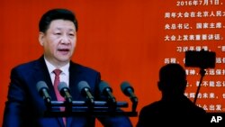 Seorang pengunjung museum militer di Beijing mengambil swafoto dekat gambar Presiden China Xi Jinping (24/10). (AP/Andy Wong)