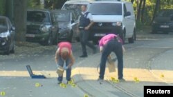 Seorang pakar penjinak bom tampak menggeledah sebuah mobil di lingkungan Woluwe St Pierre, Brussel, 30 Juni 2018 (foto: Reuters TV via Reuters)