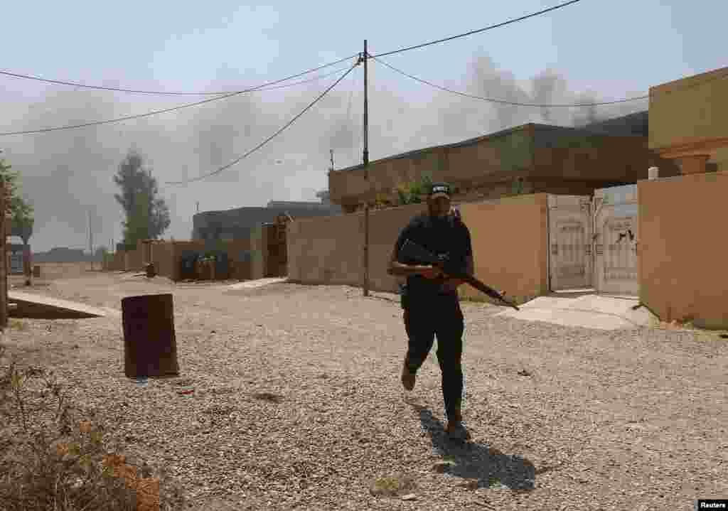 &quot;Asaib Ahlul Haq&quot; shia guruhi jangchisi otishmadan o&#39;zini panaga olmoqda, 1-sentabr, 2014-yil.