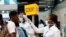 FILE - A health worker checks the temperature of a traveler as part of the coronavirus screening procedure at the Kotoka International Airport in Accra, Ghana, Jan. 30, 2020.