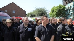 紧急救援人员为伦敦高层公寓大火的受害者默哀(2017年6月19日)