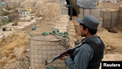 Polisi Afghanistan melakukan pengawasan di luar pangkalan mereka di provinsi Kunduz (26/11). 