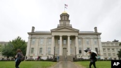 FILE - In this Oct. 2, 2014, photo, students walk across campus at the University of Iowa in Iowa City, Iowa.