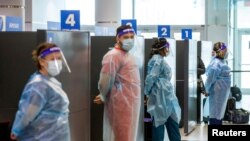 Para petugas kesehatan bersiap untuk melakukan tes COVID-19 terhadap para penumpang yang tiba di Bandara Pearson di Toronto, Ontario, Kanada, pada 1 Februari 2021. (Foto: Reuters/Carlos Osorio)