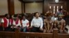 Activists Dano Anes Tabuni, right, Ambrosius Mulait, 2nd right, Paulus Suryana Ginting, Arina Elopere, 3rd left, Charles Kossay, 2nd left, and Isay Wenda, left, wait for their trial in Jakarta, Jan. 20, 2020.