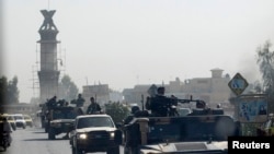 FILE - A military convoy travels along the main road of Kandahar as seen from the glass window of a U.S. military armored vehicle, in Afghanistan, Oct. 5, 2010. 