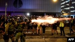 A policeman fires tear gas at protesters to disperse them after a march against a controversial extradition bill in Hong Kong on July 21, 2019. -