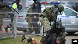 Polisi menahan seorang pria saat demo oleh kelompok oposisi untuk memprotes hasi pemlihan presiden, di Minsk, Belarus, Minggu, 1 November 2020.