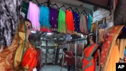 A salesman cleans a cloth shop in Mumbai, India, June 8, 2020. India is reopening its restaurants, shopping malls and religious places in most of its states after a more than 2-month-old lockdown.