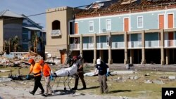 A body is removed after being discovered during a search of a housing structure in the aftermath of Hurricane Michael in Mexico Beach, Florida, Oct. 12, 2018.