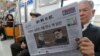A passenger reads a newspaper with headline of a planned summit meeting between North Korean leader Kim Jong Un and U.S. President Donald Trump, left, at subway train in Seoul, South Korea, March 10, 2018. The White House tried to swat away criticism Friday that the U.S. is getting nothing in exchange for agreeing to a historic face-to-face summit between President Donald Trump and North Korean leader Kim Jong Un. 