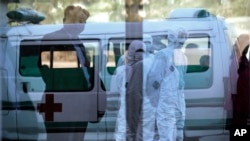 지난해 10월 북한 평양 순안공항에 보호복을 입은 보건 요원들과 구급차가 대기해있다. (자료사진)