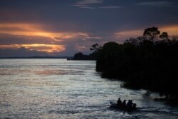 FILE - A small boat navigates on the Solimoes River near Manaus, Brazil, May 22, 2014.