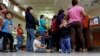 FILE - Immigrants who entered the U.S. illegally stand in line for tickets at the bus station after they were released from a U.S. Customs and Border Protection processing facility in McAllen, Texas. 