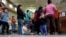 FILE - Immigrants who entered the U.S. illegally stand in line for tickets at the bus station after they were released from a U.S. Customs and Border Protection processing facility in McAllen, Texas. 