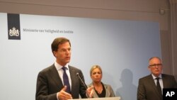 Perdana Menteri Belanda Mark Rutte, kiri, dalam konferensi pers menjelaskan pemerintah Belanda menunda pengiriman tentara bersenjata untuk menjaga lokasi jatuhnya pesawat MH17.