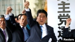 PM Jepang Shinzo Abe (tiga dari kiri) dan anggota parlemen partainya mengangkat kepalan tangan mereka ke atas sambil mengucapkan kebulatan tekad untuk memenangkan pemilihan majelis rendah mendatang, di markas partai mereka di Tokyo, Jepang, 28 September 2017. 