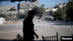 FILE - A member of Palestinian Hamas security forces walks past a Hamas site that was hit in an Israeli airstrike, in Al-Mughraqa on the outskirts of Gaza City, Aug. 9, 2018.