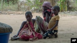 FILE - A woman and children watch as Rwandan soldiers patrol in the village of Mute, in Cabo Delgado province, Mozambique, on Aug. 9, 2021. There has been a surge of new attacks by Islamist militants in Cabo Delgado in early 2024.
