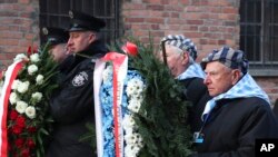 Survivors carry a wreath at the Auschwitz Nazi death camp in Oswiecim, Poland, Jan. 27, 2020. 