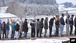 File d'attente de migrants pour une distribution de vêtements chauds en prévision de l'hiver à la frontière entre l'Autriche et l'Allemagne àHanging, Autriche le dimanche 22 novembre, 2015. (AP Photo / Kerstin Joensson)