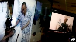 Video clips show China's jailed Nobel Peace laureate Liu Xiaobo lying on a bed receiving medical treatment at a hospital, left, and Liu saying wardens take good care of him, on a computer screens in Beijing, June 29, 2017.