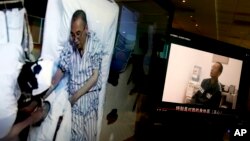 Video clips show China's jailed Nobel Peace laureate Liu Xiaobo lying on a bed receiving medical treatment at a hospital, left, and Liu saying wardens take good care of him, on a computer screens in Beijing, June 29, 2017.