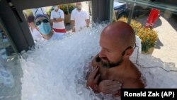 Perenang es Austria Josef Koeberl berada di dalam kabin kaca berisi es untuk memecahkan rekor dunia manusia, Melk, Sabtu, 5 September 2020. (Foto: AP/Ronald Zak)