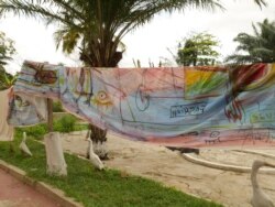Fabric painted by Sel Kofiga hangs at Kantamanto market, in Accra, Ghana, Sept. 22, 2020. (Stacey Knott/VOA)