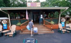 Mike Bond carries boxes as he prepares for the expected Memorial Day weekend visitors to Hall's Camp Store at the Vineyard Campground and Cabins on Grapevine Lake, May 28, 2021, in Grapevine, Texas.
