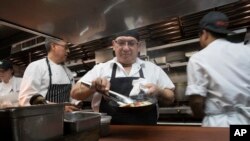 Chef Jacinto Guadarrama, kiri, mempersiapkan masakan dengan bantuan staf dapur di Gotham Bar and Grill, New York, 27 November 2018 (foto: AP Photo/Mary Altaffer)