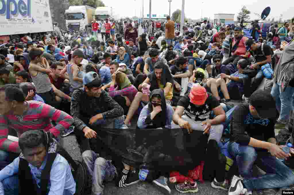 Migrants sit on the ground near the border with Hungary in Horgos. Hungarian Prime Minister Viktor Orban announced that under new security measures that went into effect Tuesday his administration will be tough on those who cross the border illegally.
