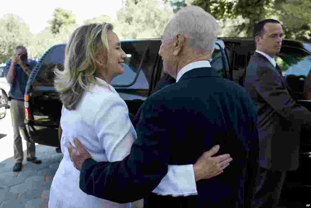 Israel's President Shimon Peres, right, walks U.S. Secretary of State Hillary Clinton, to her car following their meeting in Jerusalem, July 16, 2012. 
